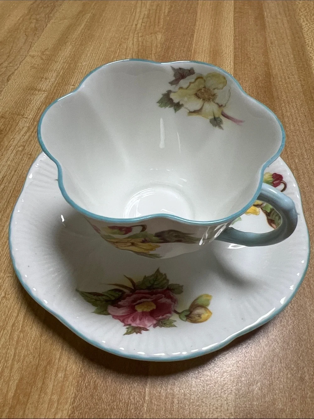 Floral Porcelain Teacup and Saucer in White with Blue Trim